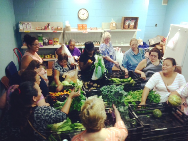 Women choose vegetables from the food bank