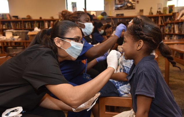 Health professionals check Orange Center Elementary School students' health metrics